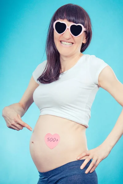 Donna felice in gravidanza mostrando carta con iscrizione 500 +, programma sociale in Polonia — Foto Stock