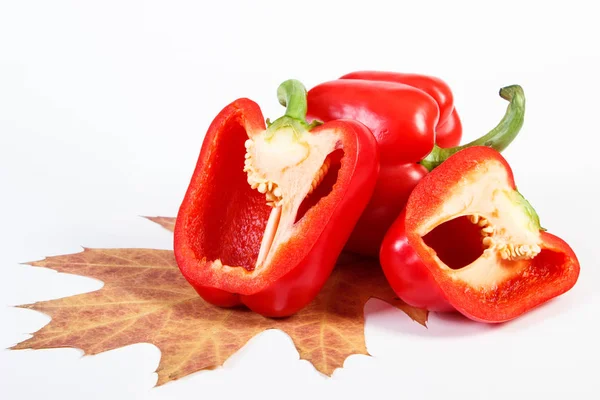 Red ripe peppers with autumnal leaf on white background, healthy nutrition and autumn concept — Stock Photo, Image