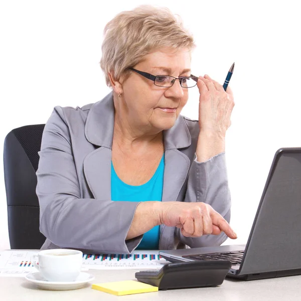 Femme d'affaires âgée travaillant avec un ordinateur portable à son bureau — Photo