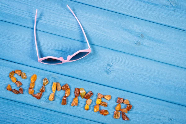 Gafas de sol y palabra verano hechas de piedras ámbar en pizarras azules, concepto de hora de verano —  Fotos de Stock