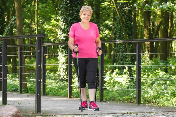 Anciana mujer mayor practicando el senderismo nórdico, concepto de estilos de vida deportivos en la vejez — Foto de Stock