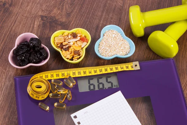 Tape measure on digital scale, tablets, dumbbells and muesli, healthy food and slimming concept — Stock Photo, Image