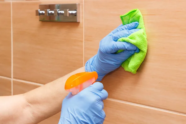 Mano de mujer mayor limpiando azulejos del baño usando paño de microfibra con detergente, concepto de tareas domésticas — Foto de Stock