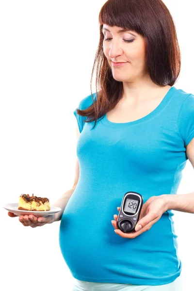 Несчастная беременная женщина с глюкозой метр и кусок чизкейка, диабет и уровень сахара во время беременности — стоковое фото