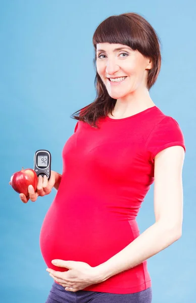 Donna in gravidanza azienda mela e glucosio metro con un buon livello di zucchero risultato, diabete e nutrizione durante la gravidanza — Foto Stock