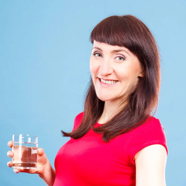 Mujer sonriente sosteniendo en la mano vaso de agua, estilo de vida saludable y concepto de hidratación — Foto de Stock