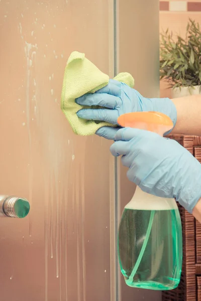Hand of senior woman cleaning shower using green microfiber cloth and detergent, household duties concept — Stock Photo, Image