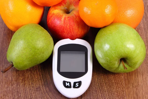 Glükóz mérő ellenőrzése a vércukorszintet és a friss, érett gyümölcsök, a cukorbetegség és a egészséges táplálkozás — Stock Fotó