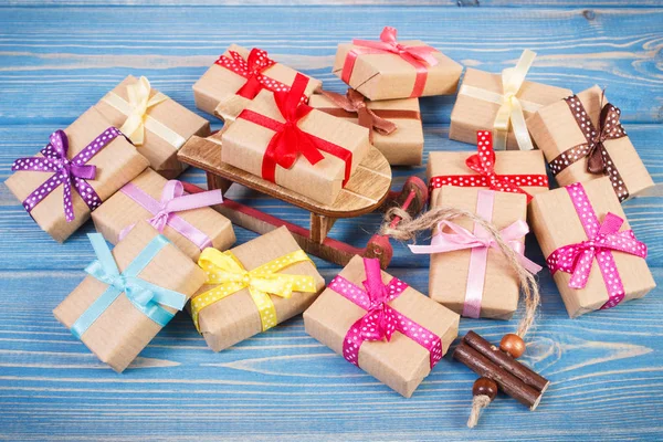Fa szánkó és becsomagolt ajándékok szalagokkal, karácsonyi vagy más ünnep, kék táblák — Stock Fotó