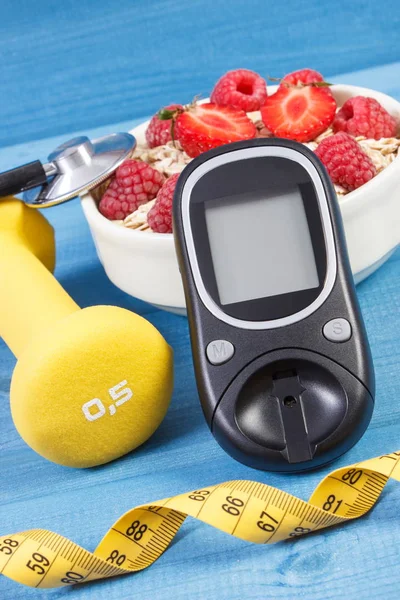 Glucose meter, fresh oatmeal with fruits, centimeter and dumbbells, concept of checking sugar level during diabetes