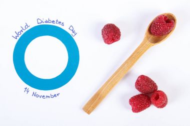 Dünya Diyabet Günü ve beyaz arka plan, sağlık kavramı üzerinde taze ahududu sembolü