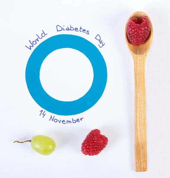 Símbolo do dia mundial da diabetes e framboesas maduras frescas no conceito branco de cuidados de saúde — Fotografia de Stock