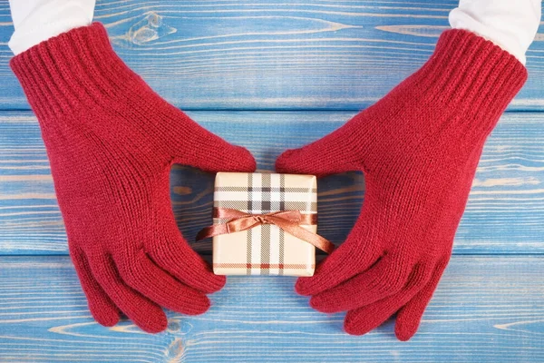 Mains de femme en gants avec cadeau pour Noël ou autre célébration — Photo