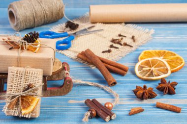 Aksesuar, dekorasyon ve eski mavi kurullarında ahşap kızak ile Noel için sarılmış hediyeler