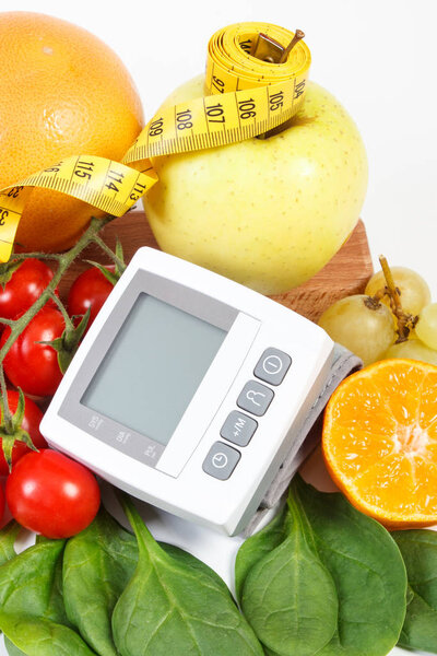 Монитор артериального давления, фрукты с овощами и сантиметром, концепция здравоохранения
