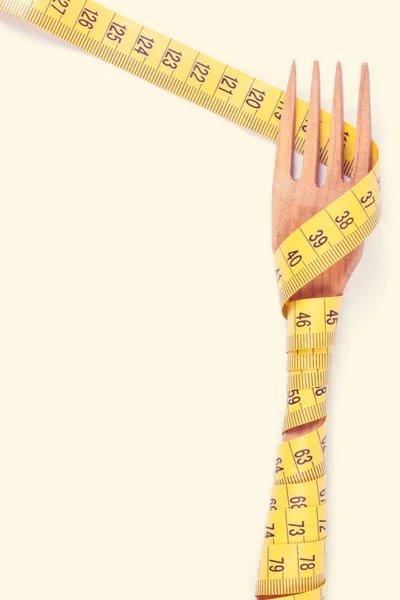 Houten vork verpakt in centimeter, concept van afvallen en een gezonde levensstijl — Stockfoto