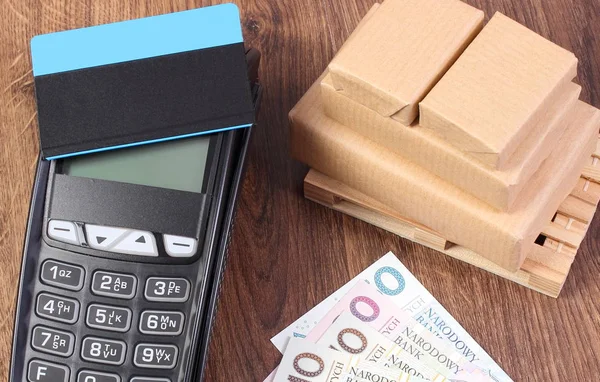 Terminal de pagamento com cartão de crédito, dinheiro em moeda polonesa e caixas embrulhadas em paletes — Fotografia de Stock