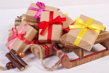 Ahşap kızak ve renkli kurdeleler ile sarılmış hediyeler Noel ya da diğer kutlama için