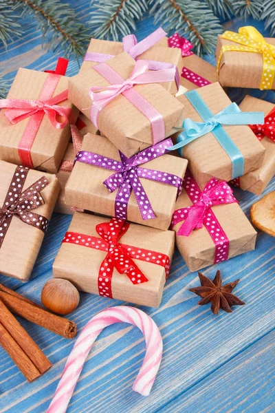 Inslagna presenter med färgglada band till jul, kryddor och spruce grenar — Stockfoto