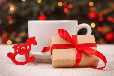 Sarılmış hediye, fincan sıcak çay veya kahve ve ışıklar içinde geçmiş, festival zaman kavramı ile Noel ağacı