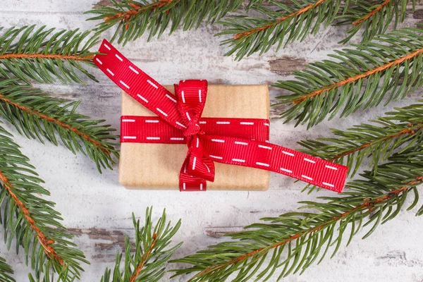 Τυλιγμένο δώρο με κόκκινη κορδέλα και ερυθρελάτης καταστημάτων για τα Χριστούγεννα ή του Αγίου Βαλεντίνου — Φωτογραφία Αρχείου