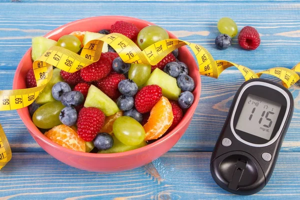Ensalada de frutas frescas, glucosímetro para comprobar el nivel de azúcar y centímetro —  Fotos de Stock