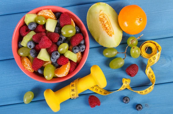 Insalata di frutta fresca preparata e centimetro con manubri, stile di vita sano e concetto di nutrizione — Foto Stock