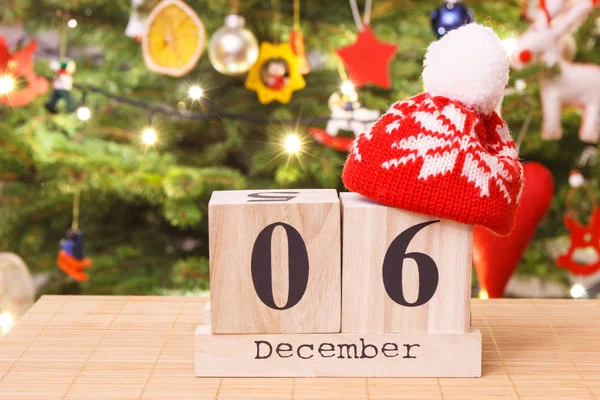 Datum 6 December med mössa och festlig träd med dekoration i bakgrunden, jul tid koncept — Stockfoto