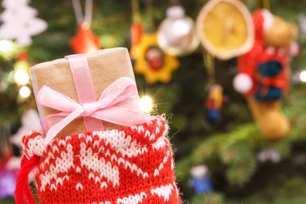 Julklapp med band i festlig strumpa och träd med dekoration, jul tid koncept — Stockfoto