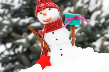 Kar kardan adam iğne yapraklı ağaç arka plan üzerinde Noel ya da Sevgililer günü için hediye ile kaplı