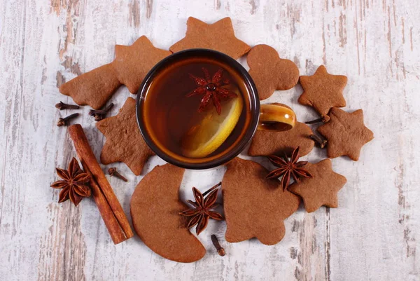 Fresh gingerbread, spices and tea on old wooden background, christmas time concept — Stock Photo, Image