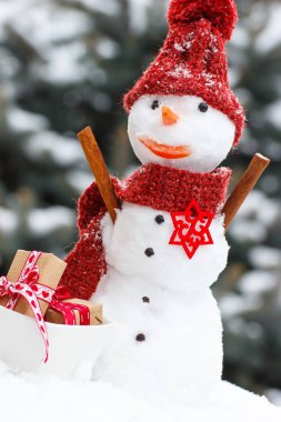 Kardan adam iğne yapraklı ağaç arka plan üzerinde Noel ya da Sevgililer günü için hediyeler ile dekore edilmiş