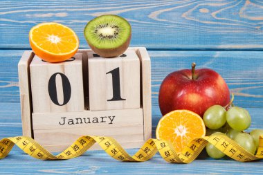 1 Ocak tarihi ile takvim, meyve ve şerit metre, yeni yıl kararları kavramı küp