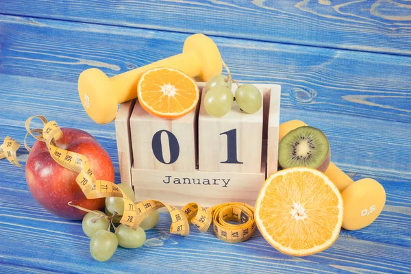 Fecha 1 Enero en el calendario cubo, frutas, mancuernas y cinta métrica, año nuevo resoluciones concepto — Foto de Stock