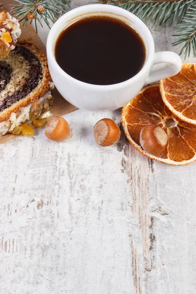 Poppy seeds cake, cup of coffee and spruce branches, dessert for Christmas time