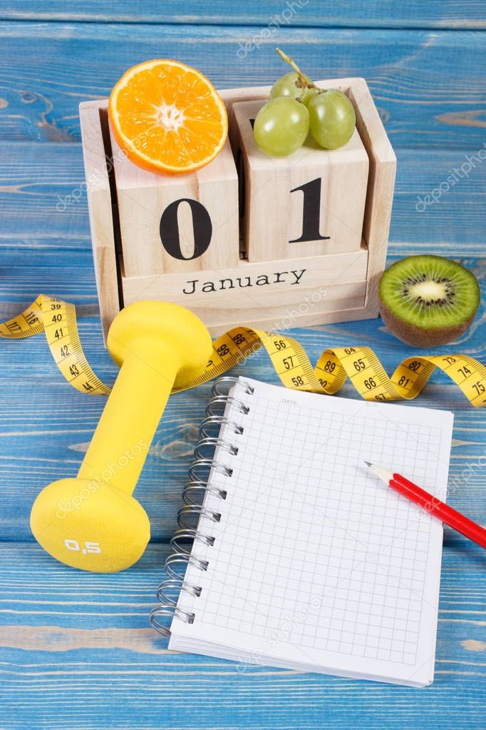 Cube calendar with date of 1 January, fruits, dumbbells and tape measure, new years resolutions