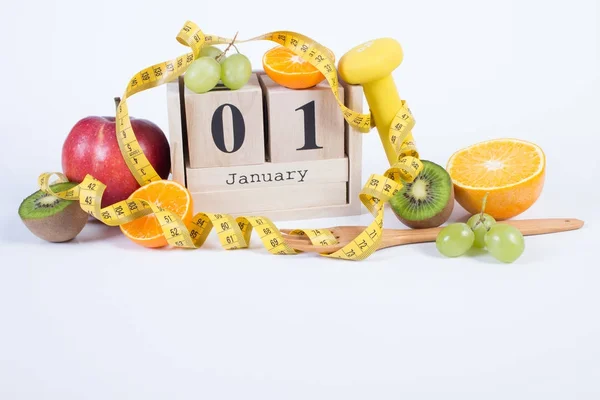 Calendrier cubique avec 1er janvier, fruits, haltères et ruban à mesurer, résolutions du Nouvel An — Photo