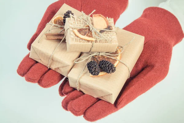 Vintage φωτογραφία, τα χέρια της γυναίκας σε μάλλινα γάντια με δώρα για τα Χριστούγεννα ή άλλη γιορτή — Φωτογραφία Αρχείου