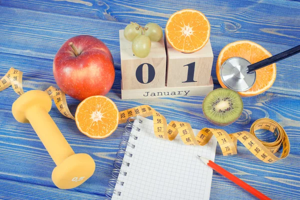 1 Janeiro de no calendário cubo, frutas, halteres e fita métrica, conceito de resoluções de anos novos — Fotografia de Stock