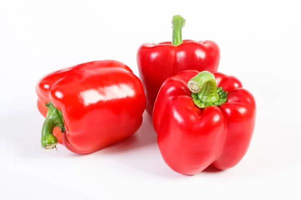 Fresh red peppers lying on white background, healthy nutrition concept — Stock Photo, Image