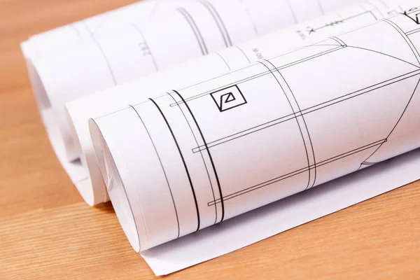 Rolls of electrical diagrams for engineer jobs lyin on desk — Stock Photo, Image