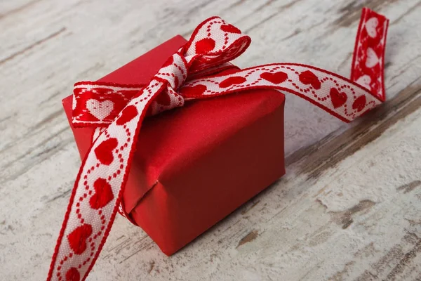 Wrapped gift with red ribbon, decoration for Valentines Day — Stock Photo, Image