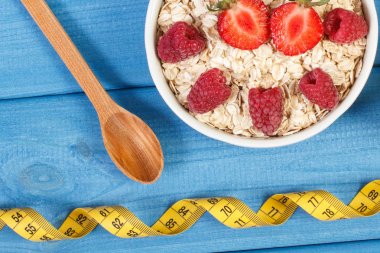 Yulaf gevreği veya yulaf ezmesi meyve ve şerit metre, sağlıklı yaşam ve beslenme kavramı