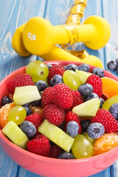 Insalata di frutta fresca preparata e metro a nastro con manubri, stile di vita sano e concetto di nutrizione — Foto Stock