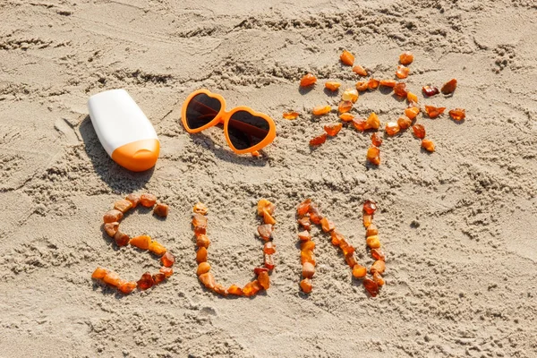 Palabra y forma del sol, gafas de sol con crema solar en la playa, hora de verano — Foto de Stock