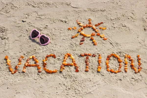 Vacanza di parola con forma di sole e occhiali da sole su sabbia a spiaggia — Foto Stock