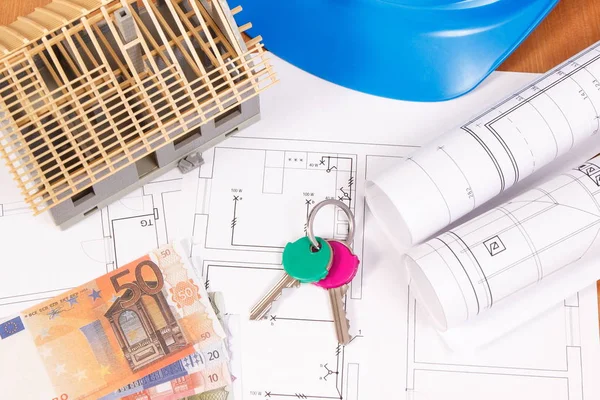 Monedas euro, llaves del hogar, diagramas eléctricos para trabajos de ingeniero y casa en construcción, costo de la casa de construcción — Foto de Stock