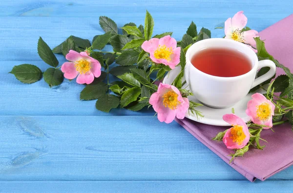 Kopje thee en wild rose bloem op boards, kopie ruimte voor tekst — Stockfoto