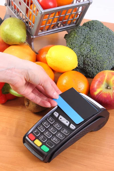 Платіжний термінал з безконтактною кредитною карткою та свіжими фруктами та овочами, безготівкова оплата за покупки — стокове фото