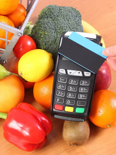 Платіжний термінал з безконтактною кредитною карткою та свіжими фруктами та овочами, безготівкова оплата за покупки — стокове фото